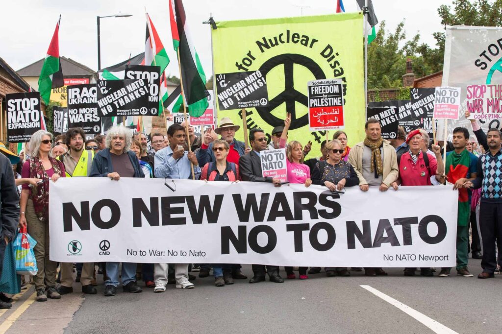 Anti-war marchers in London hold banners and posters saying "No to NATO," March 2022. Photo: CND.
