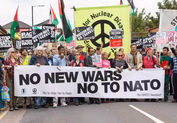 Anti-war marchers in London hold banners and posters saying "No to NATO," March 2022. Photo: CND.