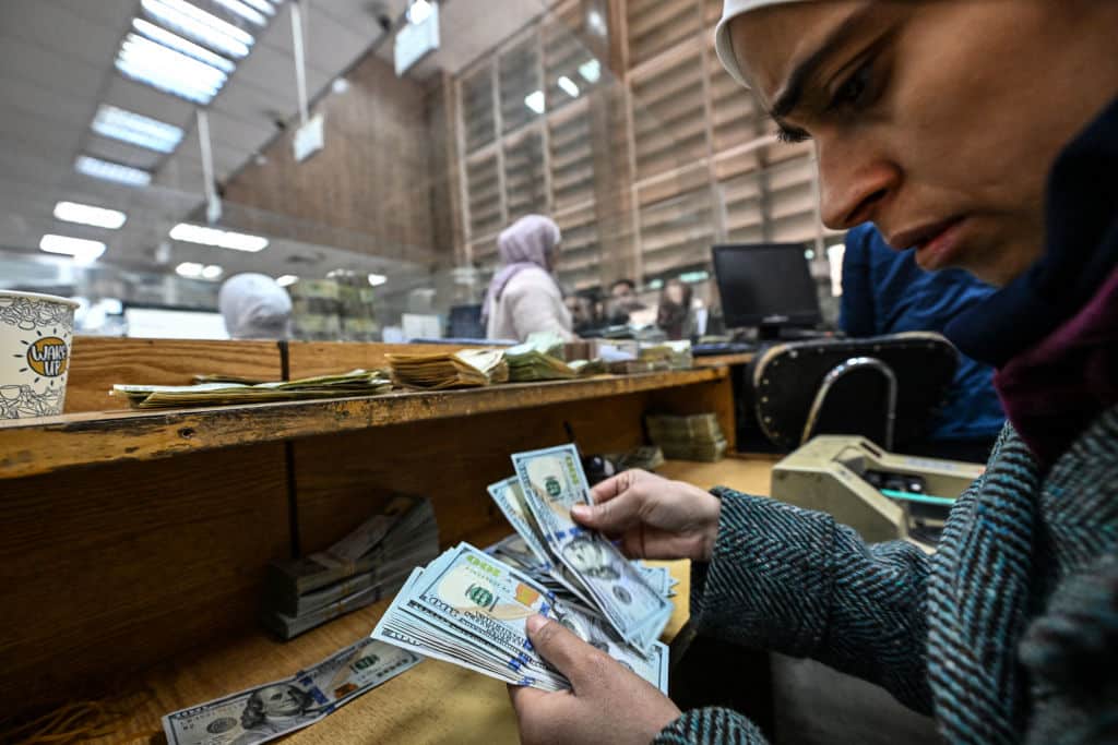 A teller counts US dollars at a commercial bank affiliated with the central bank in Damascus, December 16, 2024. Photo: Louai Beshara/AFP.