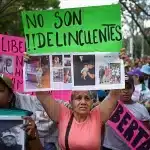 A family member of a Venezuelan deported from the US to El Salvador holds a sign that reads "They are not criminals" during a march demanding their release, in Caracas, Venezuela, on March 18, 2025. Photo: Gaby Oraa/Reuters.