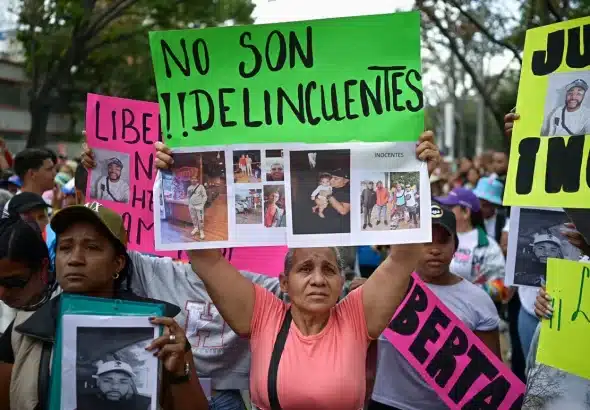 A family member of a Venezuelan deported from the US to El Salvador holds a sign that reads "They are not criminals" during a march demanding their release, in Caracas, Venezuela, on March 18, 2025. Photo: Gaby Oraa/Reuters.