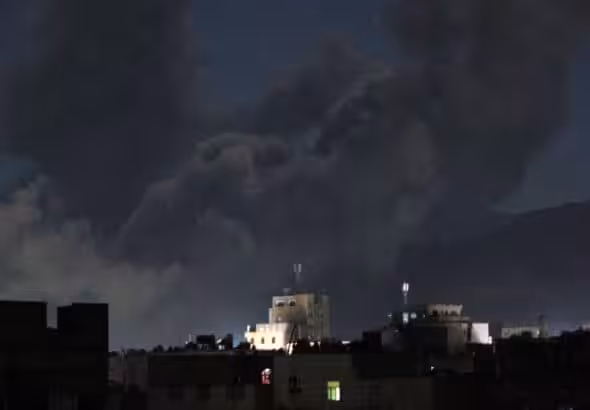 A plume of smoke billows over Sana'a, capital of Yemen, following US-British airstrikes, March 15, 2025. Photo: AFP.