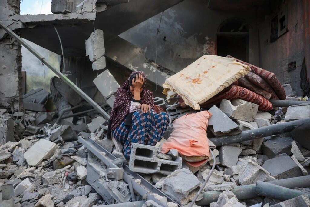 A woman cries while sitting on the rubble of her house, destroyed in an Israeli strike, in the Nuseirat refugee camp in central Gaza Strip, on March 18, 2025. Photo: AFP/file photo.