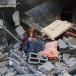 A woman cries while sitting on the rubble of her house, destroyed in an Israeli strike, in the Nuseirat refugee camp in central Gaza Strip, on March 18, 2025. Photo: AFP/file photo.