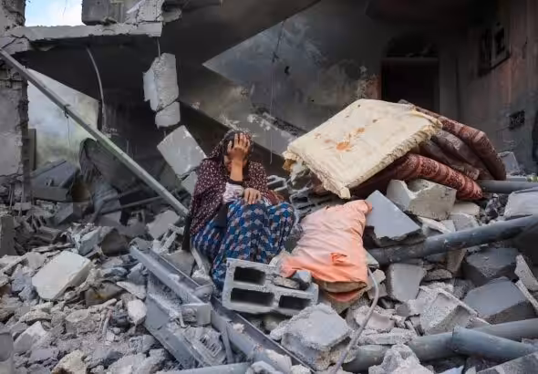 A woman cries while sitting on the rubble of her house, destroyed in an Israeli strike, in the Nuseirat refugee camp in central Gaza Strip, on March 18, 2025. Photo: AFP/file photo.