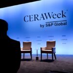 Silhouette of a passerby near the stage at the CERAWeek 2025. Photo: Bloomberg.