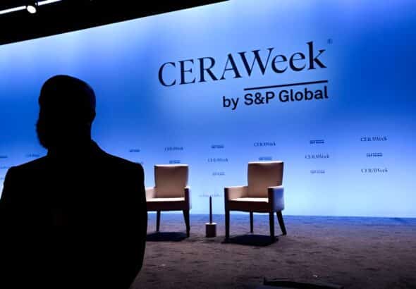 Silhouette of a passerby near the stage at the CERAWeek 2025. Photo: Bloomberg.