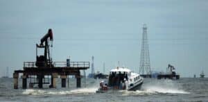 A boat with workers is seen at an oil field on Venezuela's western Maracaibo lake, on November 5, 2007. Photo: Isaac Urrutia/Reuters.