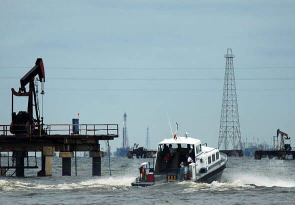 A boat with workers is seen at an oil field on Venezuela's western Maracaibo lake, on November 5, 2007. Photo: Isaac Urrutia/Reuters.