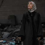 Fatima Hassouna standing amid rubble. Photo: Fatima Hassouna.