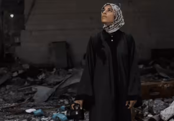 Fatima Hassouna standing amid rubble. Photo: Fatima Hassouna.