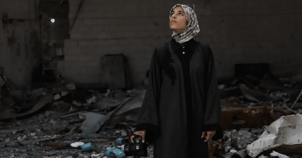 Fatima Hassouna standing amid rubble. Photo: Fatima Hassouna.