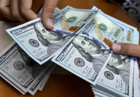 A person counts US dollar bills. Photo: AFP/File photo.