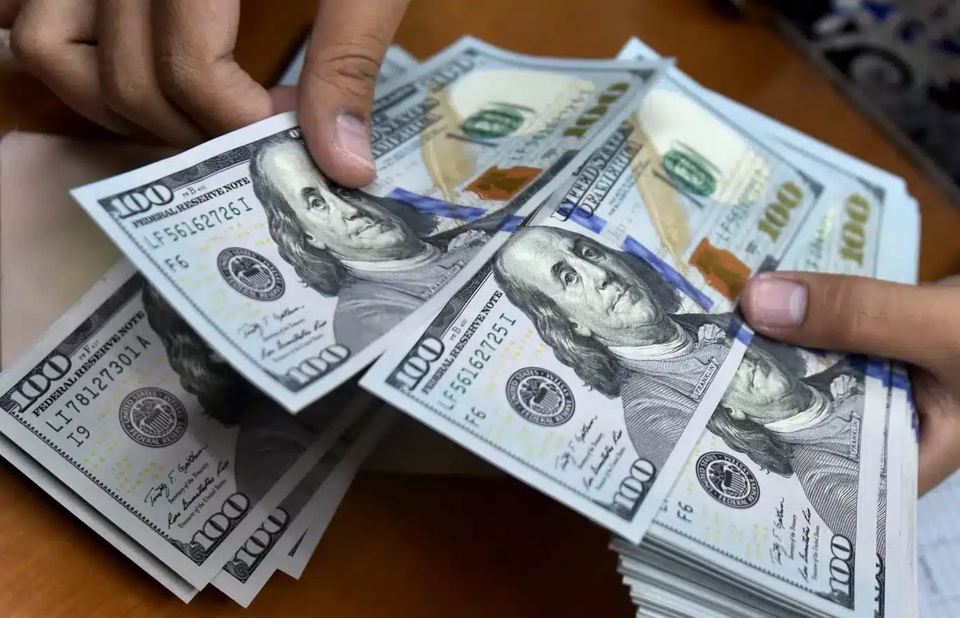 A person counts US dollar bills. Photo: AFP/File photo.