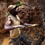One of the few remaining miners digs out soil which will later be filtered for traces of cassiterite, the major ore on tin, at Nyabibwe mine, in eastern Congo, on August 17, 2012. Photo: AP.