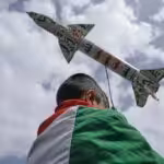 A boy draped in a Palestinian flag carries a mock rocket during a weekly anti-US and anti-Israeli rally in Sanaa, Yemen, Friday, May 9, 2025. Photo: Al Mayadeen.