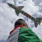 A boy draped in a Palestinian flag carries a mock rocket during a weekly anti-US and anti-Israeli rally in Sanaa, Yemen, Friday, May 9, 2025. Photo: Al Mayadeen.