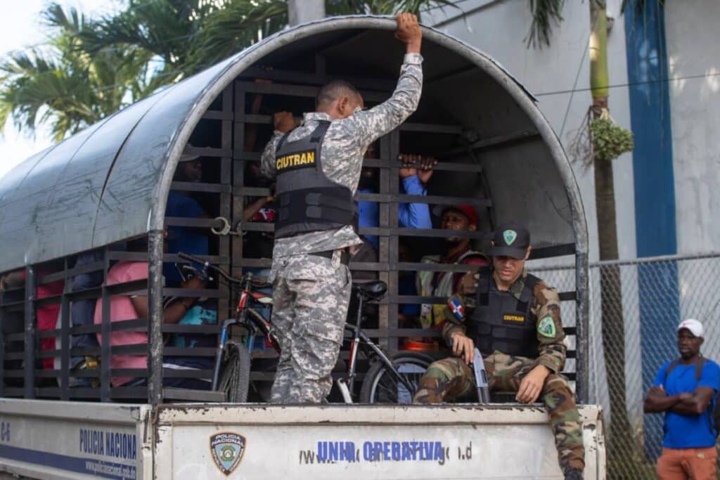 Dominican military personnel carry Haitian migrants rounded up in raids to a migrant detention center. Photo: EFE/Orlando Barria.