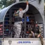 Dominican military personnel carry Haitian migrants rounded up in raids to a migrant detention center. Photo: EFE/Orlando Barria.
