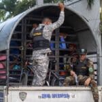 Dominican military personnel carry Haitian migrants rounded up in raids to a migrant detention center. Photo: EFE/Orlando Barria.
