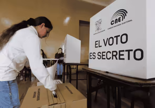 A voter deposits her ballot in a polling station in Ecuador. File photo.