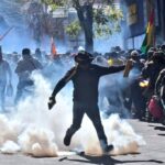 An Evo Morales supporter kicks a tear gas canister used by Bolivian police to repress those supporting Evo Morales registrations as candidate for the upcoming presidential elections. La Paz, Bolivia, on May 16, 2025. Photo: X/@evoespueblo.