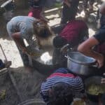 Palestinian children scrape a pot for leftover food after all meals were distributed at a community kitchen in Khan Younis, southern Gaza Strip, on Friday, May 9, 2025. Photo: AP/Abdel Kareem Hana.