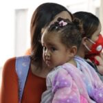 Repatriated Venezuelan migrant with her child at the Simón Bolívar International Airport. Photo: VTV.