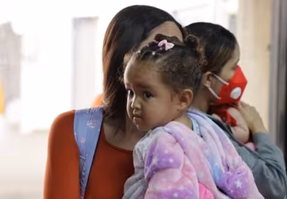 Repatriated Venezuelan migrant with her child at the Simón Bolívar International Airport. Photo: VTV.
