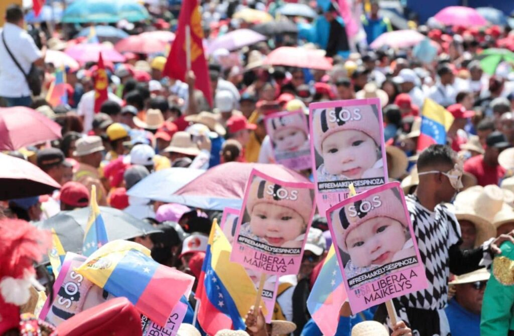 Marchers holding posters with the photo of the Venezuelan baby girl Maikelys Espinoza, who was kidnapped by US authorities, during the May Day march in Caracas on May 1, 2025. Photo: Alma Plus TV.