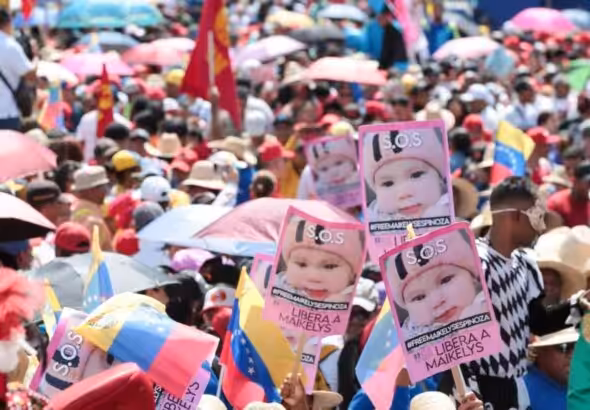 Marchers holding posters with the photo of the Venezuelan baby girl Maikelys Espinoza, who was kidnapped by US authorities, during the May Day march in Caracas on May 1, 2025. Photo: Alma Plus TV.