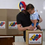 Venezuelan far-right opposition candidate Henrique Capriles casts his vote while holding his son at a polling station in Caracas during the parliamentary and regional elections held on Sunday, May 25, 2025. Photo: Federico Parra/AFP.
