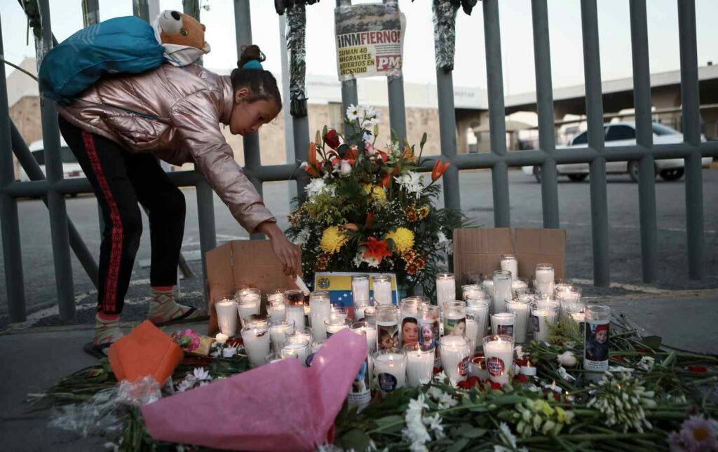 A girl lights a candle at a vigil for the victims of a fire at a migrant shelter that killed dozens in Ciudad Juárez, Mexico, on March 28, 2023. Photo: Christian Chavez/AP/file photo.