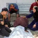 Women mourn by the body of a person who was killed following Israeli attacks on aid queues in the Sudaniya area in northwestern Gaza, at Al-Shifa hospital in Gaza City on June 14, 2025. Gaza's civil defence agency reported 41 people killed in Israeli military operations in the Palestinian territory on June 14, including 23 who were killed while waiting for food distributions. Photo: Omar Al-Qattaa/AFP.