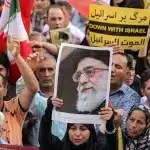 A demonstrator holds a picture of Iran's Grand Ayatollah Ali Khamenei while gathering with others during a rally in solidarity with the government against Israel's attacks on Iran and to mark Eid al-Ghadir, when according to Shiite Muslim belief the Islamic prophet Mohamed designated his nephew and companion Ali ibn Abi Talib as his successor, at Enghelab (Revolution) Square in Tehran on June 14, 2025. Photo: Atta Kenare/AFP.