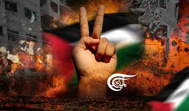A Palestinian hand behind a hand showing the victory sign. In the background war destruction sketches. Photo. Al Mayadeen.