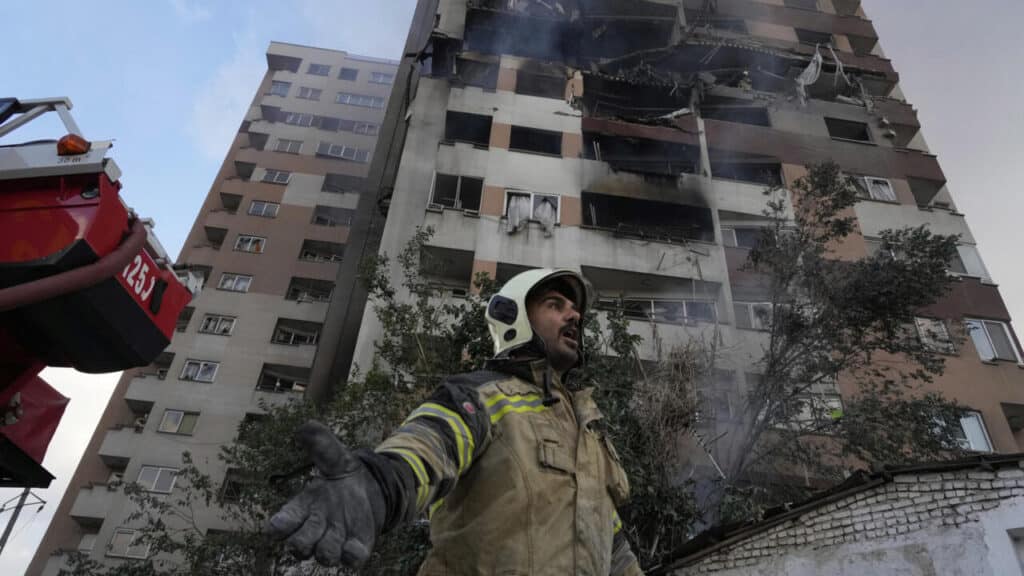 A firefighter stands in front of a building in northern Tehran hit by one of the Israeli attacks on the morning of June 13. Photo: Vahid Salemi/AP.