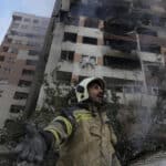 A firefighter stands in front of a building in northern Tehran hit by one of the Israeli attacks on the morning of June 13. Photo: Vahid Salemi/AP.
