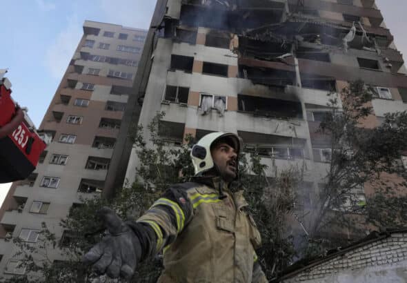 A firefighter stands in front of a building in northern Tehran hit by one of the Israeli attacks on the morning of June 13. Photo: Vahid Salemi/AP.