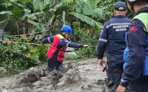Emergency response agent crossing a creek during heavy rains in Merida state, Venezuela. Photo: IG/@nicolasmaduro.