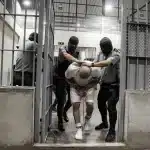 Guards push a prisoner into a cell in the CECOT maximum-security prison, El Salvador. Photo: Getty Images.