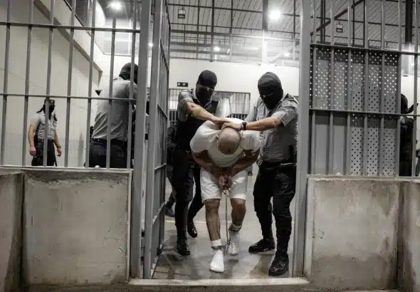 Guards push a prisoner into a cell in the CECOT maximum-security prison, El Salvador. Photo: Getty Images.