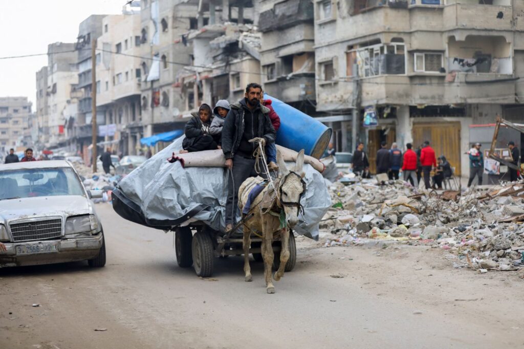 A donkey pulls a cart carrying a man, several children, and their personal belongings. Photo: CEPR/File photo.