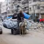 A donkey pulls a cart carrying a man, several children, and their personal belongings. Photo: CEPR/File photo.