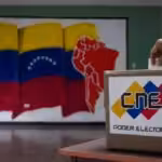 A person inserts a ballot into a ballot box bearing CNE logo. Photo: AVN.