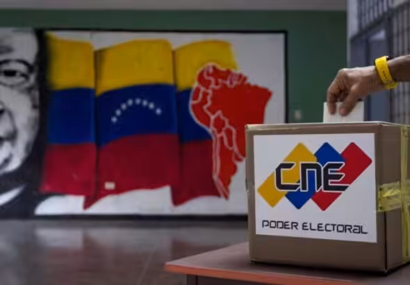 A person inserts a ballot into a ballot box bearing CNE logo. Photo: AVN.