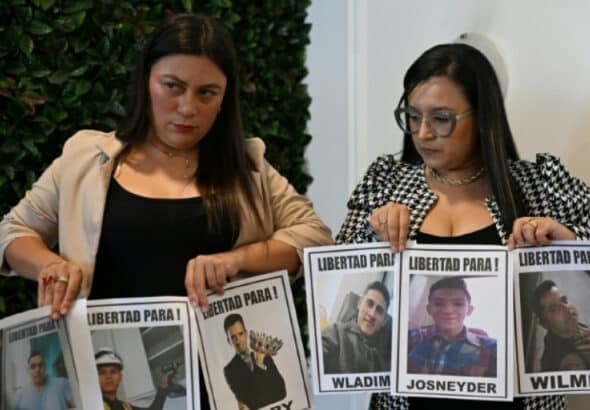 Relatives of Venezuelan migrants illegally imprisoned in El Salvador hold photos of their family members and demand their release. Photo: AFP.