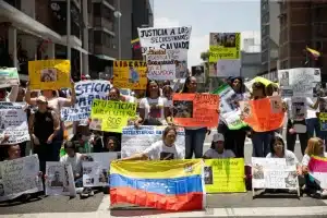 Relatives of Venezuelan abductees detained in CECOT display posters calling for justice. Photo: EFE.