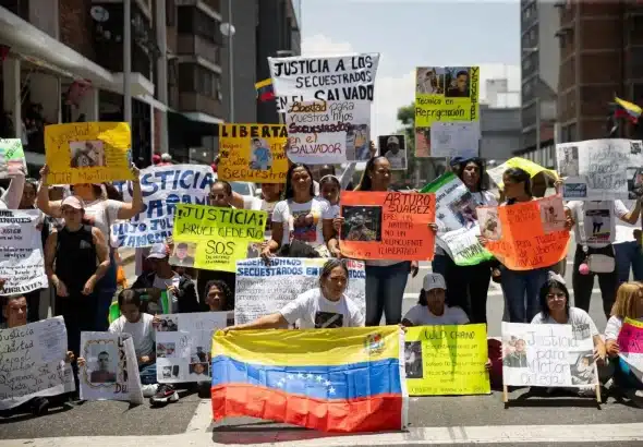 Relatives of Venezuelan abductees detained in CECOT display posters calling for justice. Photo: EFE.