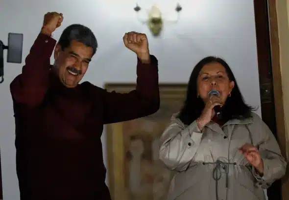 Venezuelan President Nicolas Maduro shows his reaction after the Chavista victory in the municipal elections as he stands next to Carmen Melendez, the re-elected mayor of Caracas. Photo: AP.